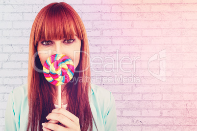 Composite image of smiling hipster woman with a lollipop