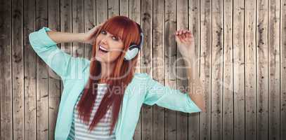 Composite image of happy hipster woman listening music with headphone