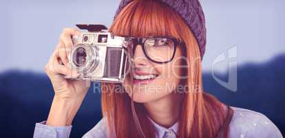 Composite image of smiling hipster woman taking pictures with a