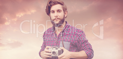 Composite image of portrait of confident hipster using camera