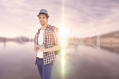 Composite image of portrait of happy man holding camera