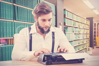 Composite image of hipster working on typewriter