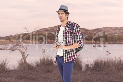 Composite image of happy man holding camera