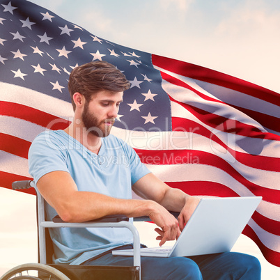 Composite image of man in wheelchair using computer