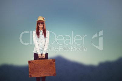 Composite image of portrait of a hipster woman holding suitcase