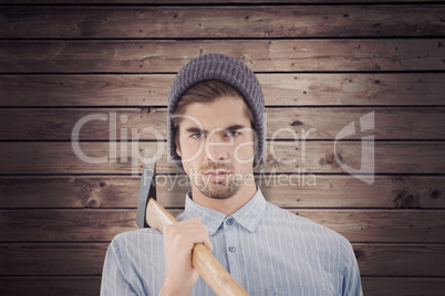 Composite image of portrait of serious hipster holding axe on sh