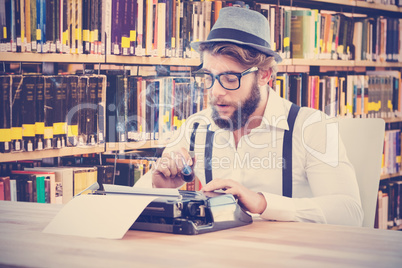 Composite image of hipster holding smoking pipe while working on