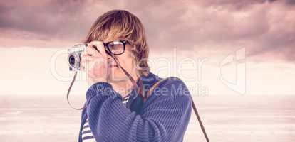 Composite image of hipster taking pictures with an old camera