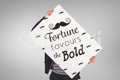 Composite image of man holding billboard in front of face Composite image of man holding billboard in front of face