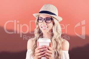 Composite image of gorgeous smiling blonde hipster holding take-