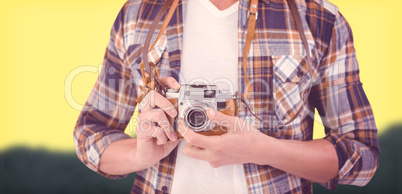 Composite image of mid section of hipster using camera