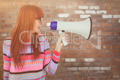 Composite image of smiling hipster woman shooting through megaph