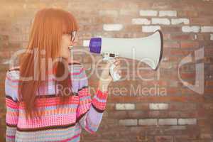 Composite image of smiling hipster woman shooting through megaph