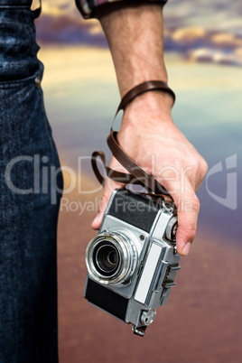 Composite image of hipster man holding digital camera