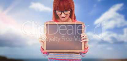 Composite image of smiling hipster woman holding blackboard