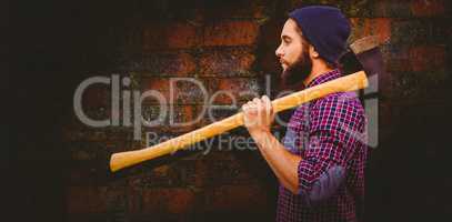 Composite image of side view of hipster with axe on shoulder