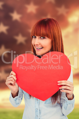Composite image of attractive hipster woman behind a red heart