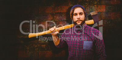 Composite image of hipster holding axe on shoulder