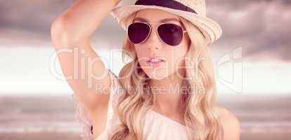 Composite image of gorgeous blonde hipster posing with straw hat