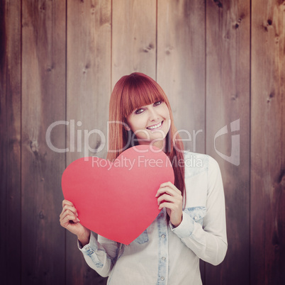 Composite image of attractive hipster woman behind a red heart