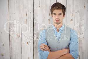 Composite image of confident businessman standing against wooden