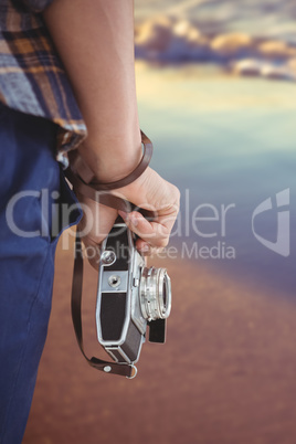 Composite image of cropped image of man holding camera