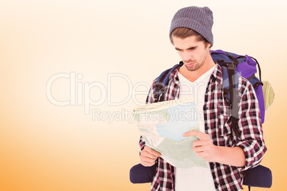 Composite image of man with luggage looking in map