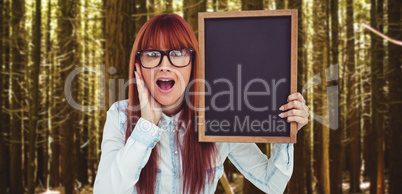 Composite image of smiling hipster woman holding blackboard