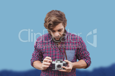 Composite image of hipster using camera