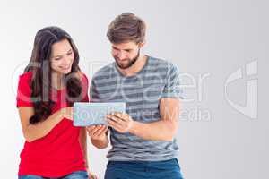 Composite image of happy couple using tablet