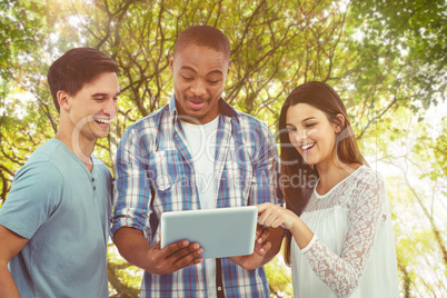 Composite image of young creative team looking at tablet