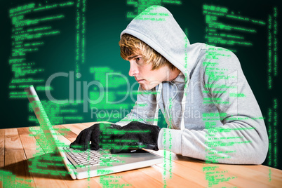Composite image of focused man with hoodie typing on laptop