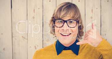 Composite image of portrait of hipster making phone sign