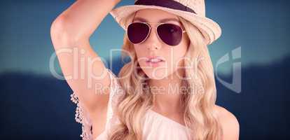 Composite image of gorgeous blonde hipster posing with straw hat