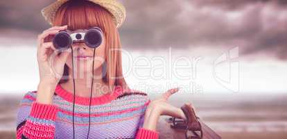 Composite image of smiling hipster woman looking through binocul