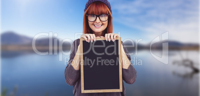 Composite image of smiling hipster woman holding blackboard