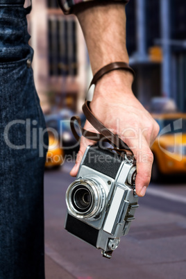 Composite image of hipster man holding digital camera