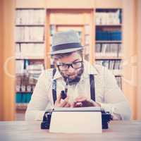 Composite image of hipster smoking pipe while working at desk