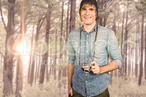 Composite image of smiling hipster man holding digital camera