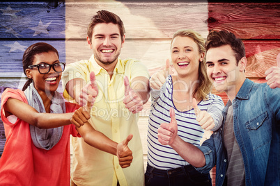 Composite image of happy creative team giving the thumbs up