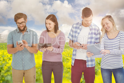 Composite image of smiling business people using electronic gadg