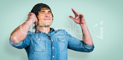 Composite image of cheerful hipster listening to music