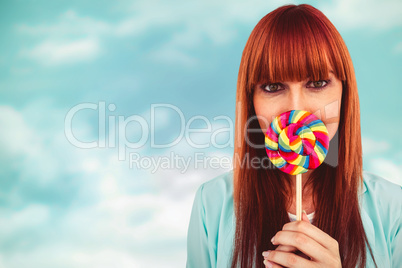 Composite image of smiling hipster woman with a lollipop