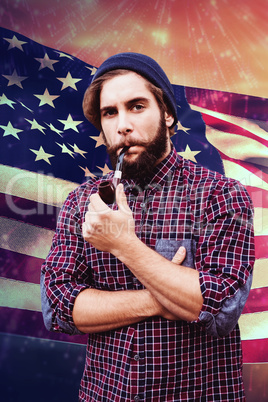 Composite image of hipster wearing knitted hat smoking pipe