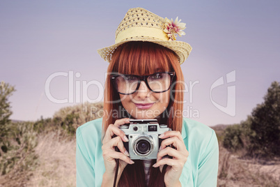 Portrait of a smiling hipster woman holding retro camera