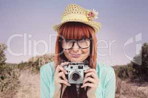 Portrait of a smiling hipster woman holding retro camera