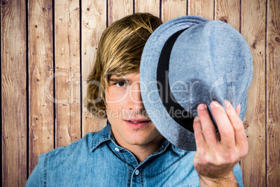 Composite image of focused hipster man hiding his face