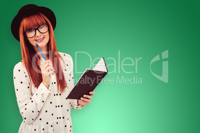 Composite image of attractive hipster woman writing on notepad