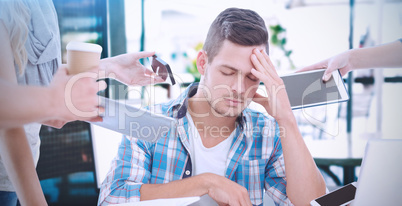 Composite image of depressed businessman with head in hand