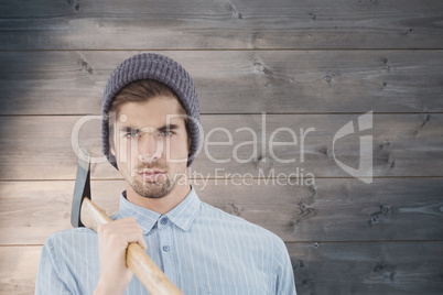 Composite image of portrait of serious hipster holding axe on sh